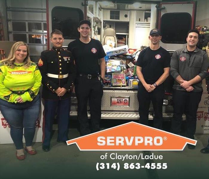 Group photo of SERVPRO employees and fire fighters.