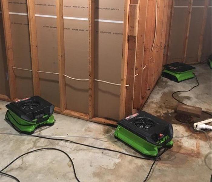 Green air movers in front of a stripped wall.